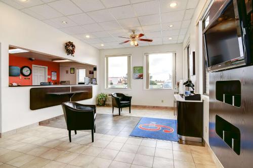 a waiting room with chairs and a flat screen tv at Motel 6-Colby, KS in Colby