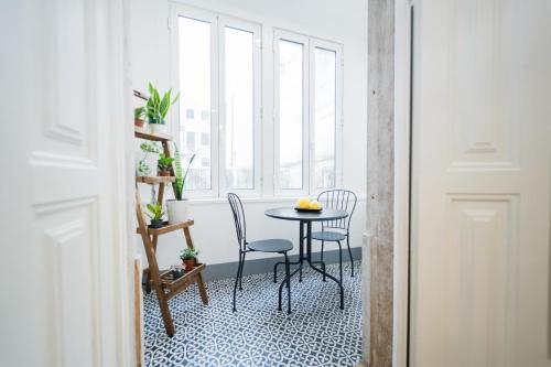 a table and chairs in a room with a window at Bairro Novo - Alojamento Local in Figueira da Foz