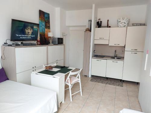 eine kleine weiße Küche mit einem Tisch und einem Bett in der Unterkunft Lovely view in Nizza