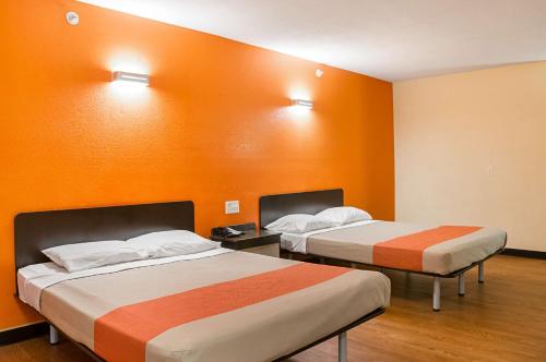 two beds in a room with orange walls at Motel 6-New Orleans, LA - Near Downtown in New Orleans