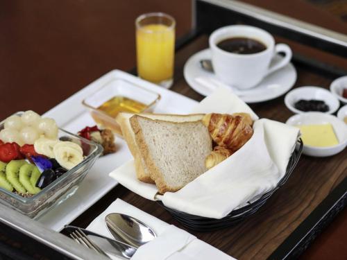 a tray with a plate of bread and a cup of coffee at Mercure Convention Center Ancol in Jakarta