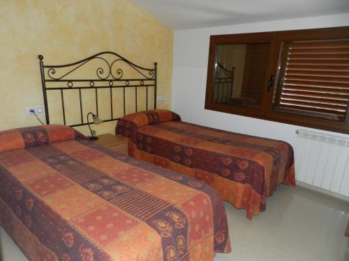 a hotel room with two beds and a window at Cal Feliuet in Passanant i Belltall
