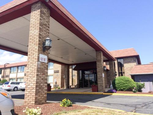 a large brick building with a parking lot at Travelodge by Wyndham Vernon CT in Vernon