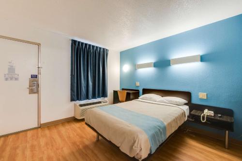 a bedroom with a large bed with a blue wall at Motel 6-Kingston, TN in Kingston