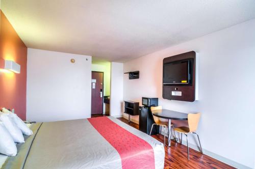 Habitación de hotel con cama, mesa y TV. en Motel 6-Lansing, IL - Chicago South, en Lansing