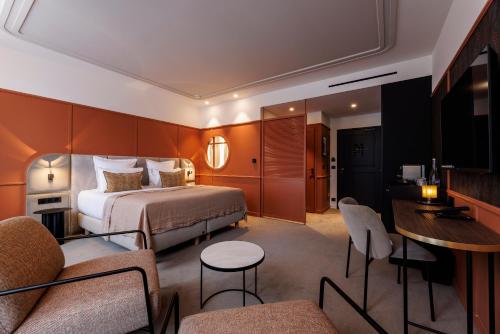 En eller flere senge i et værelse på Grand Hotel de Courtoisville