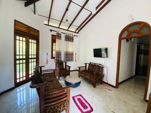 a living room with wooden furniture and a tv at VILLA Sea La THALPE in Talpe