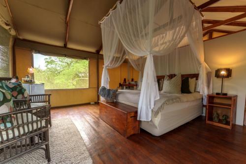 ein Schlafzimmer mit einem Himmelbett in der Unterkunft Lion Tree Top Lodge in Guernsey Nature Reserve
