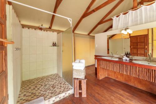 ein Badezimmer mit zwei Waschbecken und einer Dusche in der Unterkunft Lion Tree Top Lodge in Guernsey Nature Reserve