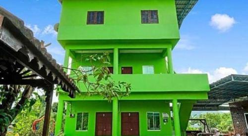 un bâtiment vert avec un toit vert dans l'établissement OYO 90462 Padang Besar Green Inn, à Padang Besar