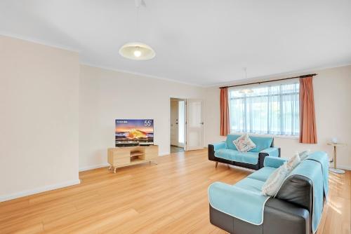 a living room with a couch and a tv at Beach House 3 mins Walk Bellerive Beach, Hobart in Bellerive