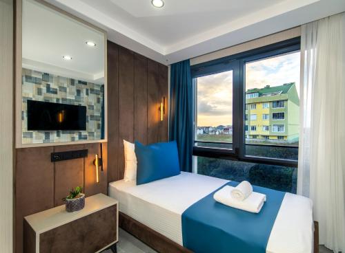 a hotel room with a bed and a window at Cosinüs Airport Hotel in Arnavutköy