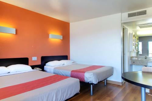 a hotel room with two beds and a table at Motel 6 Capitol Heights, MD - Washington in Capitol Heights