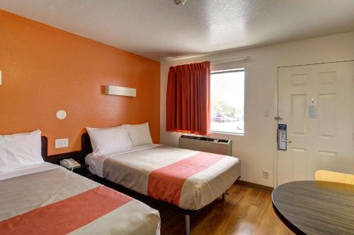 a hotel room with two beds and a table and a window at Motel 6-Amherst, OH - Cleveland West - Lorain in Amherst