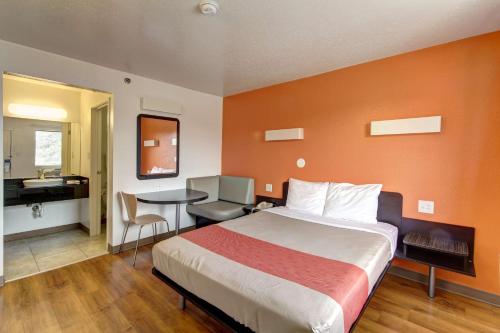 a hotel room with a bed and a desk and a table at Motel 6-Amherst, OH - Cleveland West - Lorain in Amherst