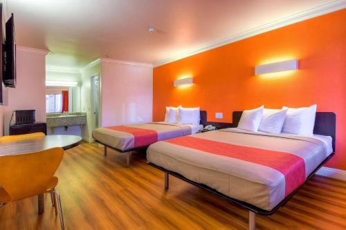 a hotel room with two beds and a table at Motel 6-Menifee, CA in Menifee