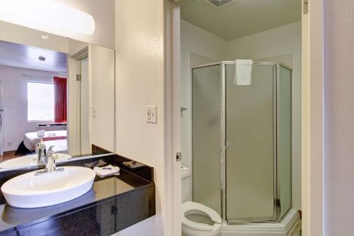 a bathroom with a sink and a glass shower at Motel 6-Amherst, OH - Cleveland West - Lorain in Amherst