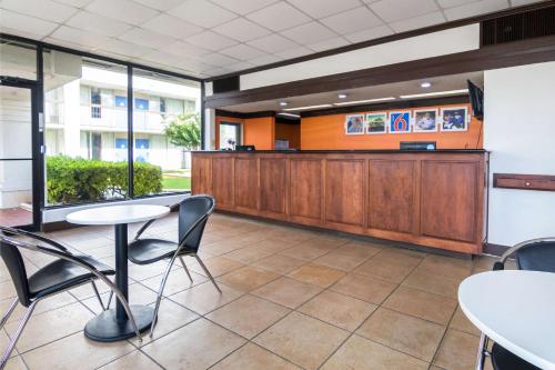 a waiting room with tables and chairs and a counter at Motel 6-Conyers, GA in Conyers