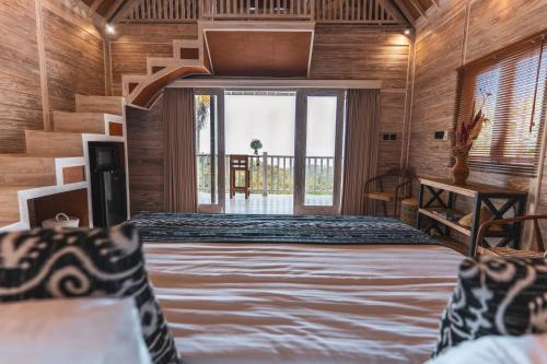 una camera con un letto e una grande finestra di Garden Terrace Bali a Gobleg