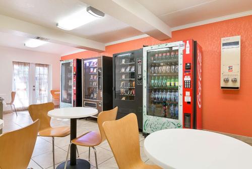 タンパにあるMotel 6-Tampa, FL - Fairgroundsのソーダマシン2台、テーブル、椅子が備わるレストラン