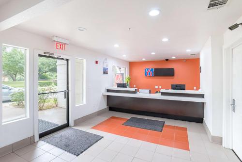 an office lobby with an exit sign on the wall at Motel 6-Grand Prairie, TX - Near Six Flags Drive in Grand Prairie