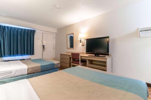 a hotel room with two beds and a flat screen tv at Motel 6-Farmington Hills, MI - Northwest - Farmington Hills in Farmington Hills