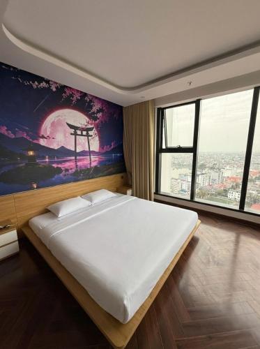 a bedroom with a large bed with a painting on the wall at QNC Taiyo Homestay in Hai Phong