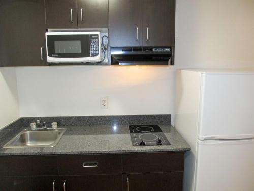 uma pequena cozinha com um lavatório e um micro-ondas em Motel 6-Augusta, GA - Fort Gordon em Augusta