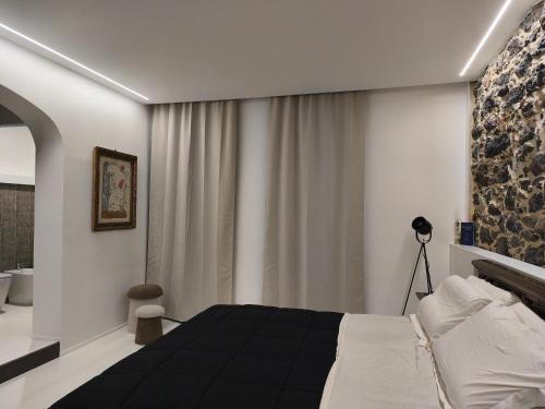 een slaapkamer met een zwart-wit bed en een badkamer bij Residenza Don Baddore in Dorgali