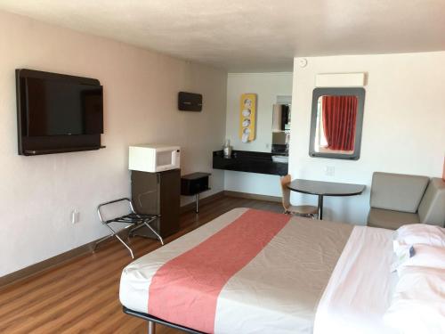 a hotel room with a bed and a flat screen tv at Motel 6-Connellys Springs, NC in Hickory