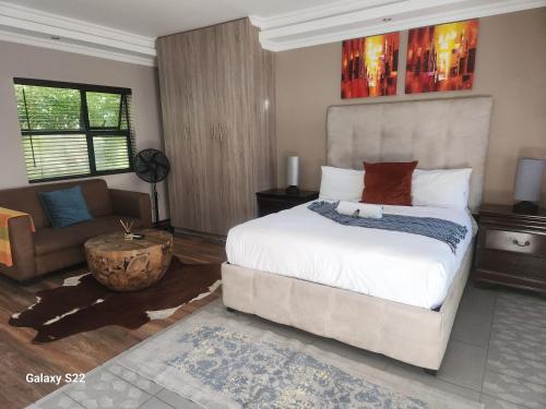 een slaapkamer met een groot bed en een bank bij 18onkuruman in Summerstrand