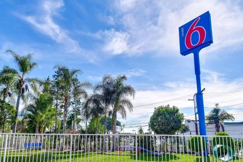 a krispy kreme sign in front of a fence at Motel 6 Garden Grove in Anaheim