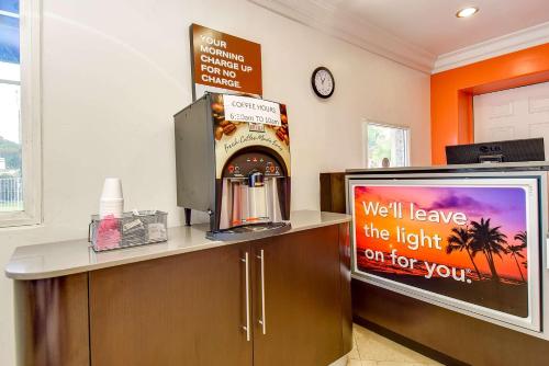 a room with a television and a sign on a counter at Motel 6 Garden Grove in Anaheim