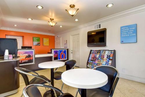 a waiting room with two tables and chairs and a tv at Motel 6 Garden Grove in Anaheim