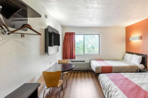 a hotel room with two beds and a table at Motel 6-Dallas, TX - South in Dallas
