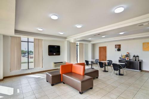 a waiting room with a couch and chairs and a tv at Motel 6-Lindale, TX in Lindale
