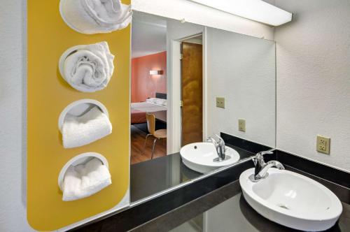 a bathroom with two sinks and two mirrors with towels at Motel 6-Lindale, TX in Lindale