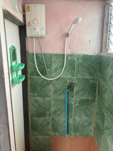 a shower with a hose hooked up to a wall at New Phiman Riverview Guesthouse in Bangkok
