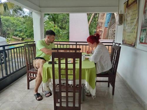 een man en een vrouw zitten aan een tafel bij Sigiri Rew Haven in Sigiriya