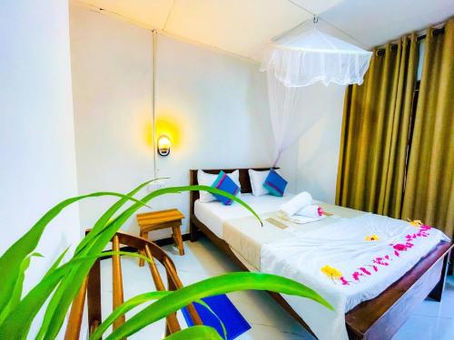 een slaapkamer met een bed en een plant bij Sigiri Rew Haven in Sigiriya