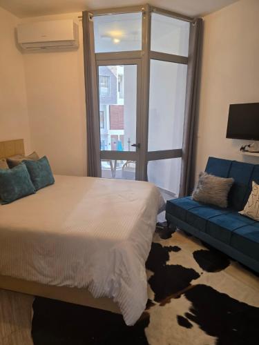 a bedroom with a bed and a blue couch at 2 Bedroom Duplex - Hurghada in Hurghada