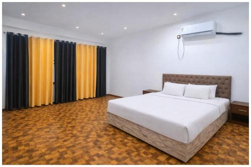 een slaapkamer met een groot wit bed en gordijnen bij Hotel Rajshree S- Gopal N Near Mathura Railway Station - Sri Krishna Janmabhoomi - Restaurant And Free Parking - Fully Air conditioning Luxuary Room - Best Hotel in Mathura