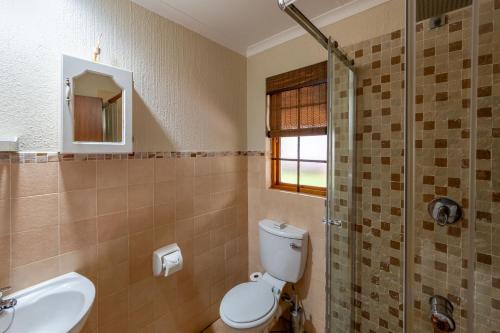 ein Badezimmer mit Toilette, Waschbecken und Dusche in der Unterkunft Kruger Park Lodge Unit No. 543 in Hazyview