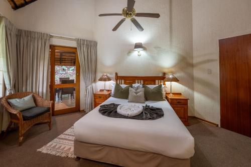 ein Schlafzimmer mit einem großen Bett und einem Deckenventilator in der Unterkunft Kruger Park Lodge Unit No. 543 in Hazyview