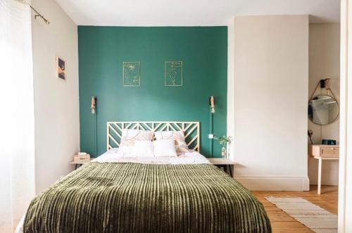 a bedroom with a bed with a green wall at L'Authentique Free parking in Mâcon