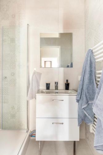 a white bathroom with a sink and a shower at L'Authentique Free parking in Mâcon
