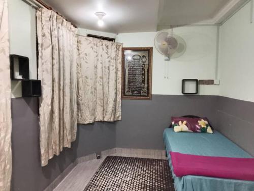 ein kleines Zimmer mit einem Bett und einem Fenster in der Unterkunft Idid homestay in Kota Belud