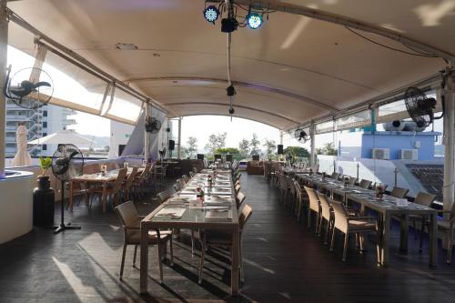 a row of tables and chairs at a restaurant at Patong Condo Tub, Roof Pool & 2-min to Beach in Patong Beach