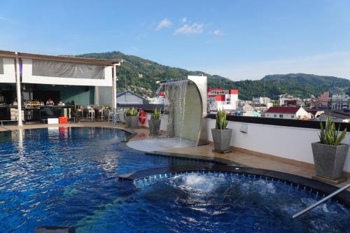 a swimming pool with a fountain on top of a building at Patong Condo Tub, Roof Pool & 2-min to Beach in Patong Beach