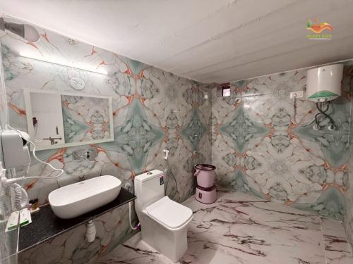 een badkamer met een wit toilet en een wastafel bij Desert Heer Resort in Sām